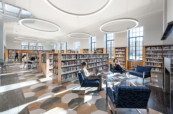 Design Ringo Star pendant luminaires in a round shape illuminate bright libraries with seating and book areas.